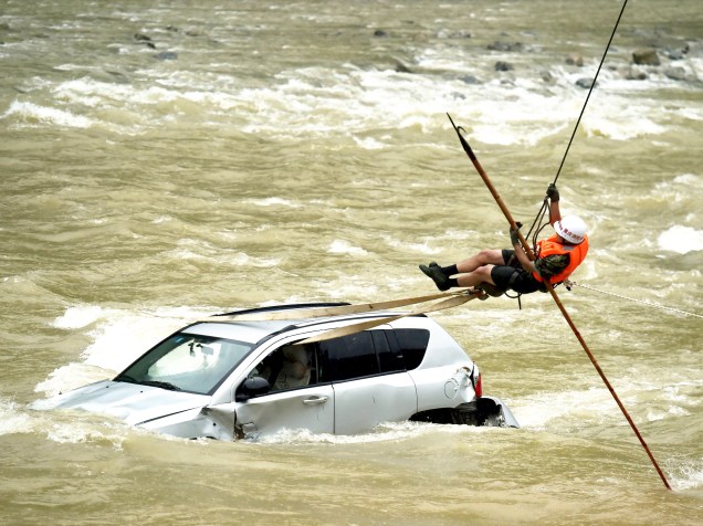Membro de uma equipe de resgate tentou chegar até um carro ilhado no meio de um rio em Chongqing, na China. De acordo com a mídia local, mais de dez veículos caíram no rio após deslizamento devido à forte chuva na região