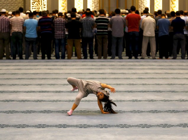 Menina foi fotografada brincando enquanto adultos faziam orações na mesquita de Ahmet Hamdi Akseki, em Ancara, capital da Turquia