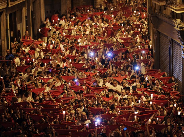 Foliões levantam lenços vermelhos e velas durante o encerramento do festival de São Firmino, em Pamplona, na Espanha - 15/07/2015