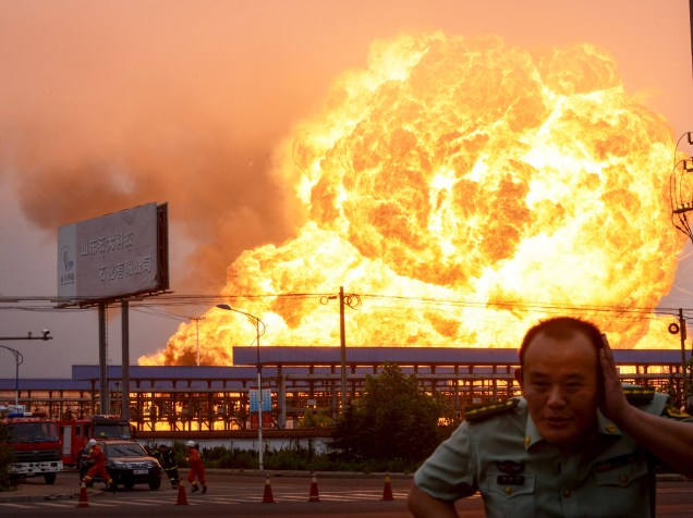 Guarda corre durante explosão em uma indústria petroquímica em Rizhao, na província de Shandong, China. De acordo com a mídia local, a explosão seguida de um incêndio, foi causada pelo vazamento de hidrocarboneto- 16/07/2015