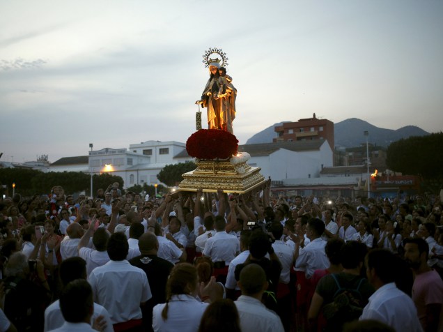 Homens em vestes tradicionais carregam a estátua de Nossa Senhora do Carmo, em processão que leva a estátua ao mar, em Málaga, Espanha - 16/07/2015
