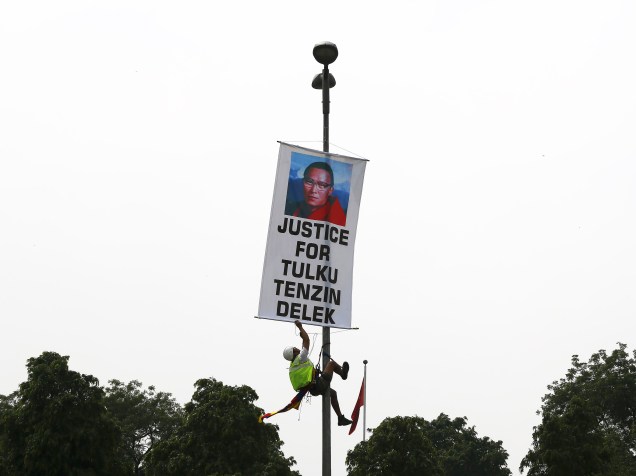 Manifestante pendura um banner em um poste durante protesto em frente à embaixada chinesa de Nova Délhi, Índia. O protesto destaca a morte prematura de Tenzin Delek Pinpoche, professor espiritual tibetano - 20/07/2015