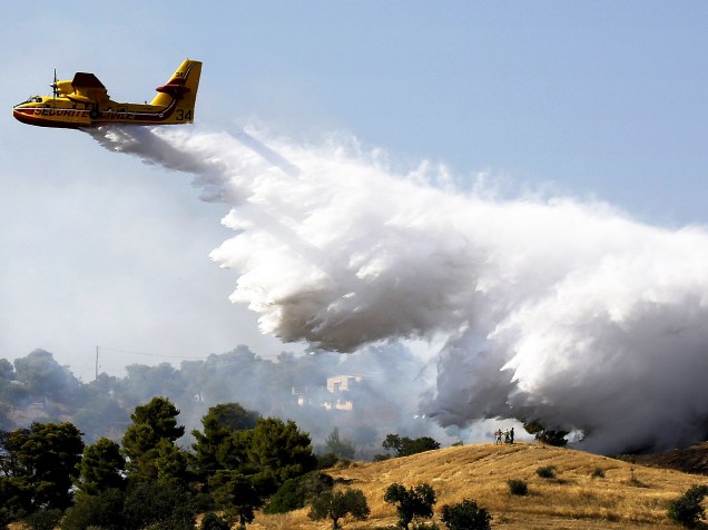 Avião despeja água sobre um incêndio que atingiu casas de veraneio da região de Argolida, no sudeste Grécia. Segundo a mídia local, dezenas de pessoas tiveram que deixar suas casas devido ao fogo - 20/07/2015
