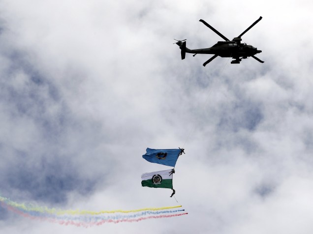 Policiais se penduram em corda com bandeiras enquanto um helicóptero faz apresentação aérea durante o Dia da Independência da Colômbia, em Bogotá - 20/07/2015