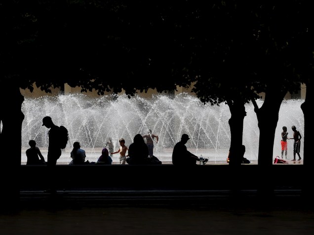 Pessoas sentam debaixo da sombra de árvores em frente a uma fonte para fugir do calor em Boston, Estados Unidos - 20/07/2015