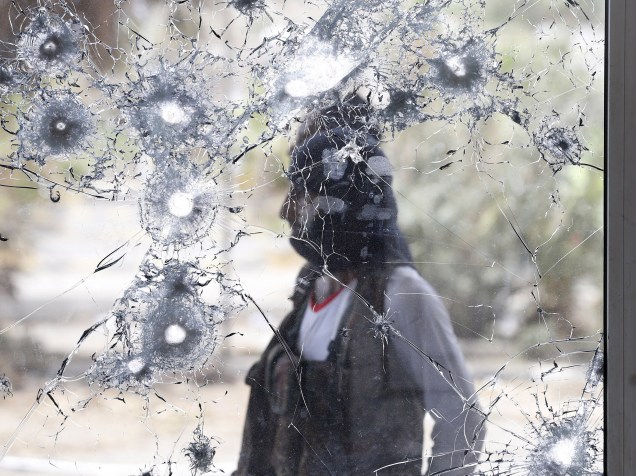 Guerrilheiro da resistência sulista é fotografado atrás de uma janela danificada enquanto monta guarda no aeroporto internacional do Iêmen - 24/07/2015