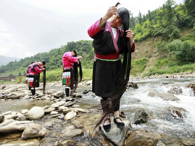 Mulheres da etnia Yao escovam o cabelo na aldeia de Guilin, na China. A vila, que tem mais de 80 mulheres com o cabelo maior que 1,4 metro, sendo o mais longo com 2,2 metros, atrai cerca de 80 mil turistas por ano