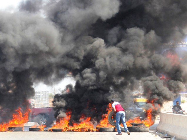 Manifestantes bloqueiam uma estrada em Jiyyeh, ao sul de Beirute, durante protesto contra uma crise na coleta de lixo na capital do Líbano - 27/07/2015