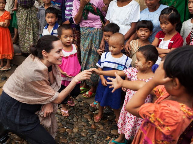 A atriz e ativista Angelina Jolie atende crianças durante visita a um campo de refugiados em Myitkyina, Mianmar