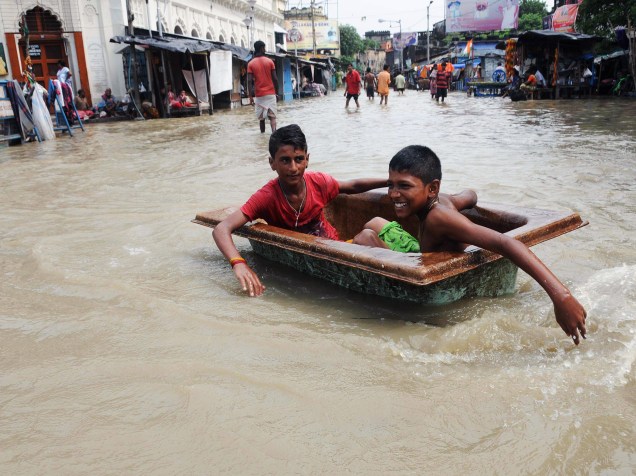 Crianças brincaram em uma rua inundada pela cheia do rio Ganges, em Calcutá, na Índia
