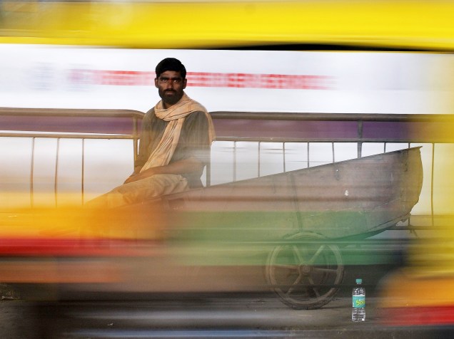 Carregador é fotografado enquanto aguarda clientes em um mercado na cidade de Bengaluru, na Índia - 04/08/2015