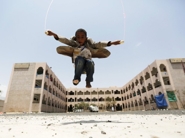 Garoto pula corda em frente a uma escola onde refugiados foram abrigados após conflitos na província de Houthi, ao norte do Iêmen - 05/08/2015