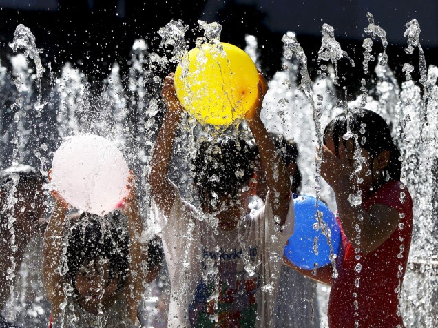 Crianças brincam em fonte de água em parque de Tóquio, no Japão. Pela primeira vez na história o país vem registrando recordes de calor, com temperaturas ultrapassando os 35ºC - 05/08/2015