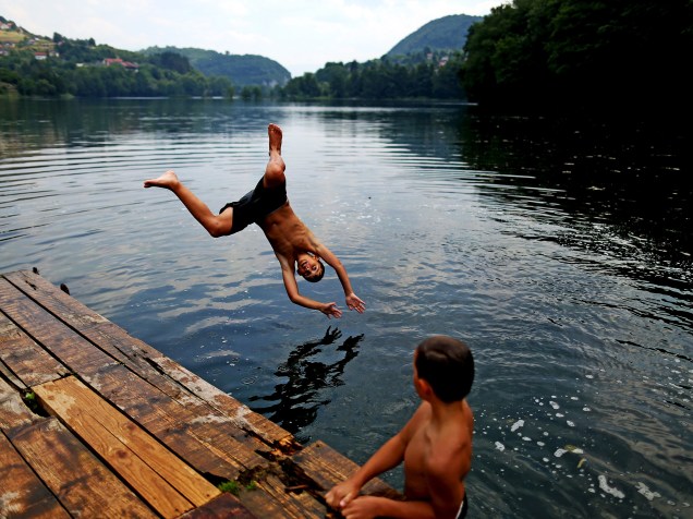 Menino salta em um lago na cidade de Jajce, na Bósnia e Herzegovina - 05/08/2015