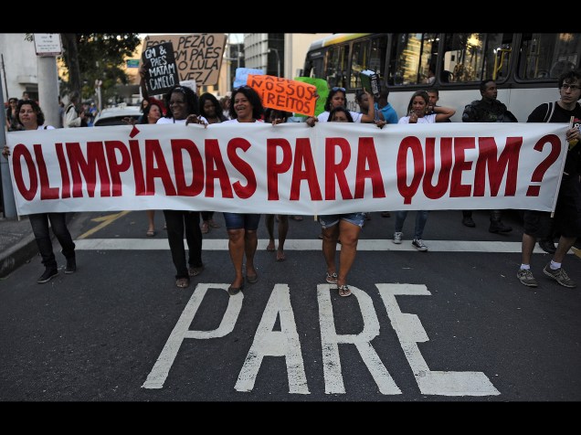 Manifestantes seguram uma faixa escrita "Olimpíadas para quem?" durante protesto contra os Jogos Olímpicos, no Rio de Janeiro - 05/08/2015