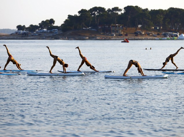 Pessoas praticam yoga sobre pranchas, na costa do mar adriático em Medulin, na Croácia - 06/08/2015