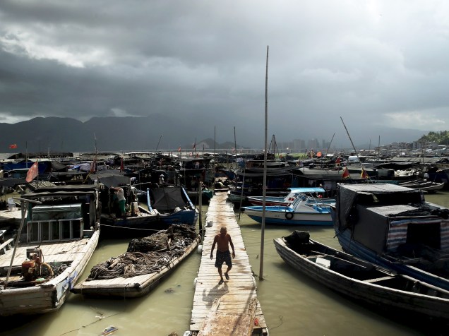 Pescador caminha em um ponto de Ningde, província de Fujian, China, enquanto o tempo se fecha ao fundo anunciando a chegada do tufão Soudelor