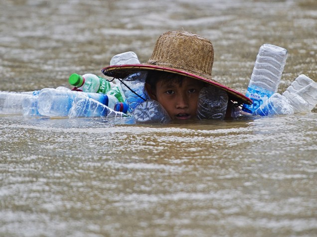 Menino nada em meio a uma enchente em um vilarejo nos arredores da cidade de Hinthada, em Mianmar - 11/08/2015