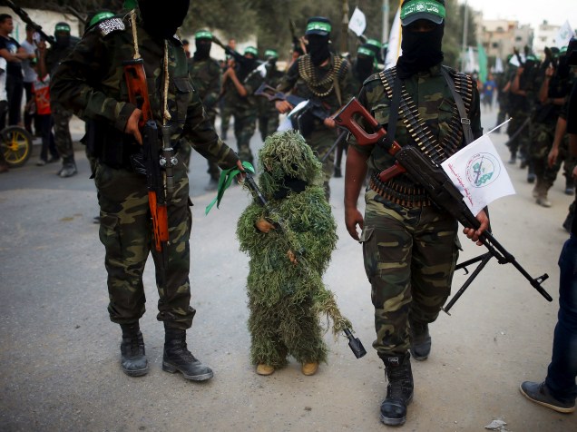 Menino palestino mascarado participa de um desfile militar do Hamas em Beit Hanoun, cidade no norte da Faixa de Gaza - 11/08/2015