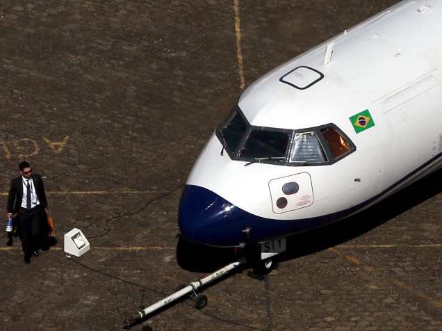 Homem passa por uma aeronave durante a LABACE, maior feira de aviação executiva da América Latina, no Aeroporto de Congonhas, em São Paulo - 11/08/2015