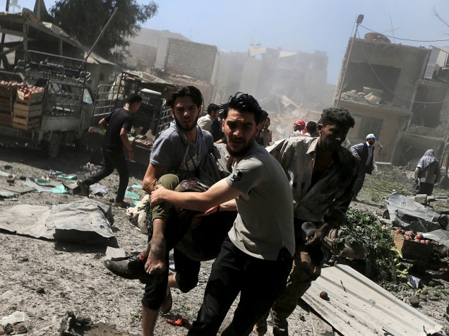 Homens carregam ferido após ataques aéreos realizados por forças leais ao presidente da Síria, Bashar al-Assad, em um mercado em Damasco. Os ataques do governo sírio a áreas habitadas por rebeldes mataram ao menos 31 pessoas nesta quarta-feira - 12/08/2015