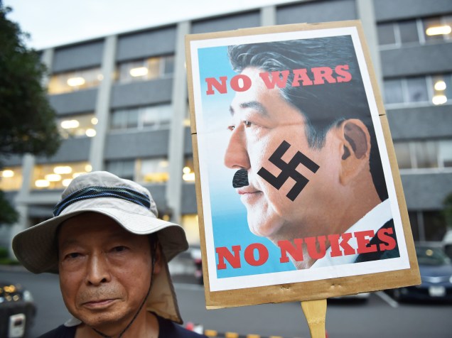 Homem protesta perto da residência do primeiro-ministro japonês, Shinzo Abe. Os manifestantes são contra propostas aprovadas no parlamento que mudam a política de defesa do país