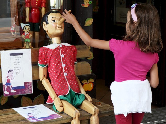 Menina brinca com um boneco Pinóquio em uma loja de Viena, Áustria - 21/08/2015