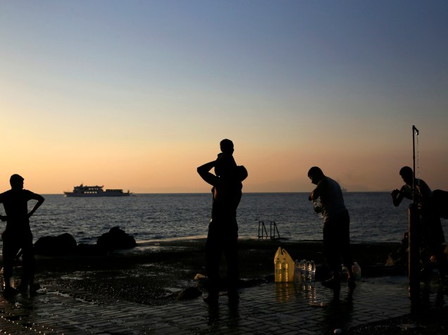 Migrantes são vistos durante o amanhecer na ilha grega de Lesbos, localizada no nordeste do mar Egeu - 21/08/2015