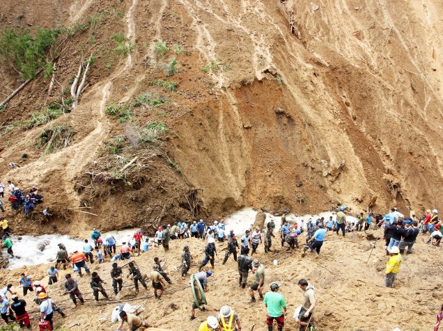 Equipes de resgate procuram por mineiros que foram atingidos por um deslizamento de terra em Mankayan, no norte das Filipinas. Mais de 30 mil famílias foram evacuadas e milhares de casas destruídas após a passagem do tufão Goni - 24/08/2015