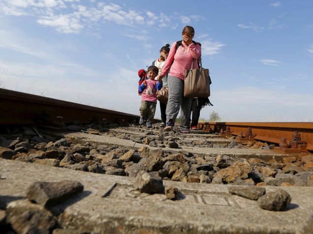 Migrantes sírios caminham por um trilho após cruzar a fronteira entre Hungria e Sérvia, próximo a Roszke. O governo húngaro começou a contrução de uma cerca de 175km para conter o fluxo de migrantes que buscam refúgio na União Européia - 25/08/2015