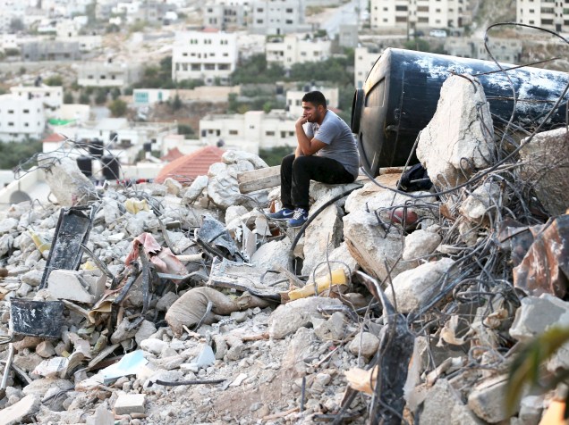 Palestino senta sobre os destroços de uma casa destruída por tropas israelenses após confronto em Jenin, na Cisjordânia. Segundo a mídia local, pelo menos cinco palestinos e um soldado ficaram feridos - 01/09/2015
