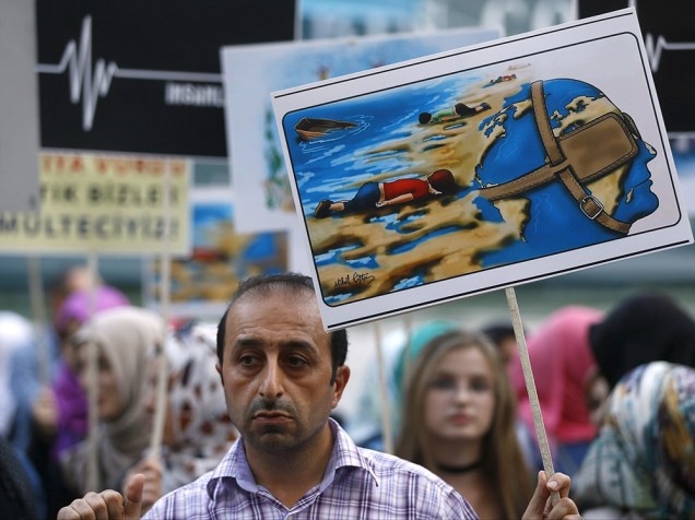 Homem, com um desenho retratando o menino sírio que morreu afogado, durante uma manifestação pelos direitos dos refugiados em Istambul, Turquia