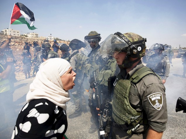 Mulher palestina discute com policial durante protesto na aldeia de Nabi Saleh, perto de Ramallah, Cisjordânia