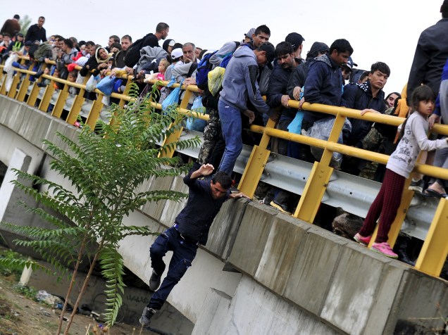 Homem pula de uma ponte enquanto tenta passar um bloqueio polícial junto a outros imigrantes, em Gevgelija, Macedônia. Ao estilo da Hungria, a Macedônia considera construir uma cerca para impedir o crescente fluxo de imigrantes vindos do sul - 10/09/2015