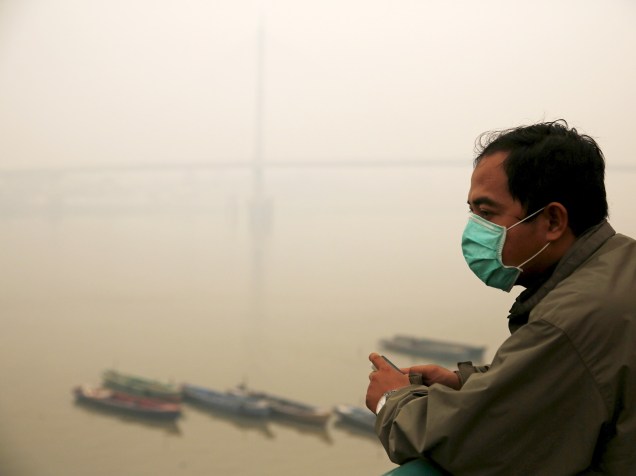 Homem usa máscara para se proteger do alto nível de poluição registrado em Jambi. A população da Indonésia vem sofrendo com a fumaça causada por queimadas florestais, o que obrigou o presidente do país, Joko Widodo, a anunciar que tomará medidas para amenizar o problema - 15/09/2015