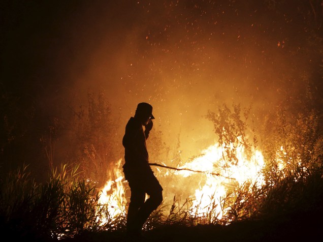 Oficial da agência local de Gestão de Calamidades (BPBD) tenta extinguir um incêndio na região da Sumatra Meridional, na Indonésia - 16/09/2015
