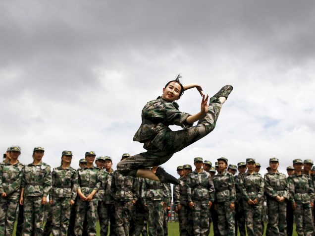 Estudante se apresenta para suas colegas durante uma pausa em sua formação militar, em Kunming, na China