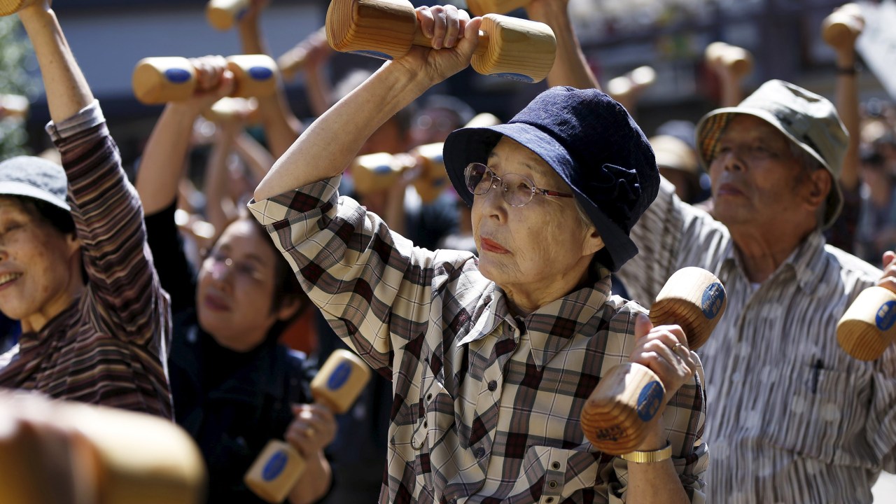 Idosos fazem exercícios com halteres de madeira durante evento que promove o 'Respeito pelo dia do Idoso' em um templo de Tóquio, no Japão - 21/09/2015