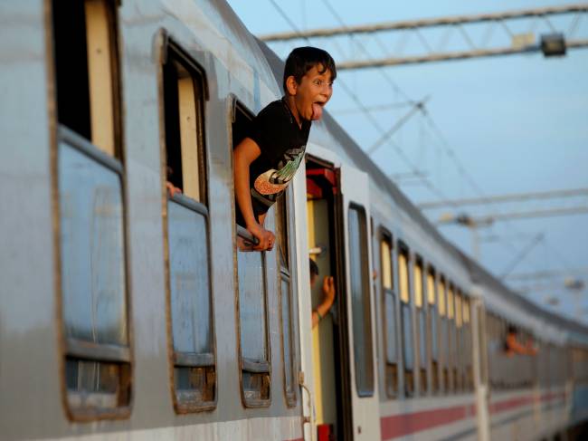 Jovem imigrante se pendura para fora da janela de um trem enquanto espera a partida da estação de Tovarnik, Croácia. Mais de 30 mil imigrantes, muitos deles refugiados da Síria, têm entrado na Croácia vindos da Sérvia desde terça-feira passada (15), quando a Hungria barrou a entrada na União Européia pela fronteira do sul - 22/09/2015