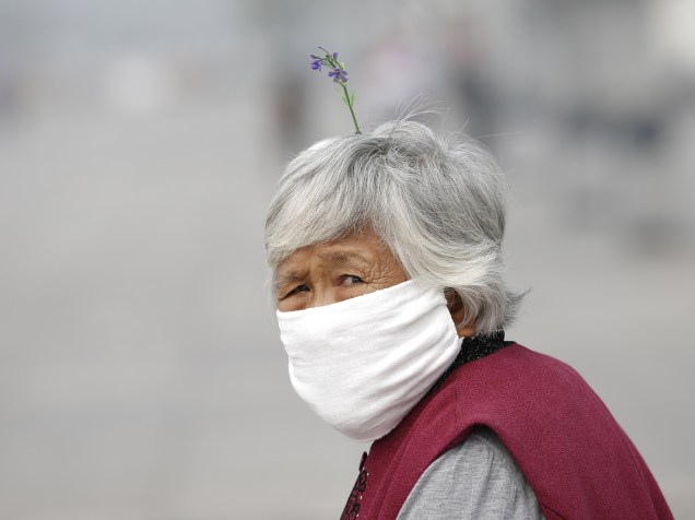 Mulher usa máscara durante dia nublado próximo ao Estádio Nacional de Pequim, China - 24/09/2015