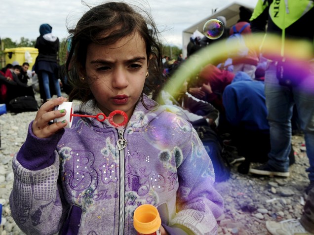 Menina refugiada soprou bolhas de sabão em um acampamento na cidade de Gevgelija, na Macedônia, após cruzar a fronteira com a Grécia