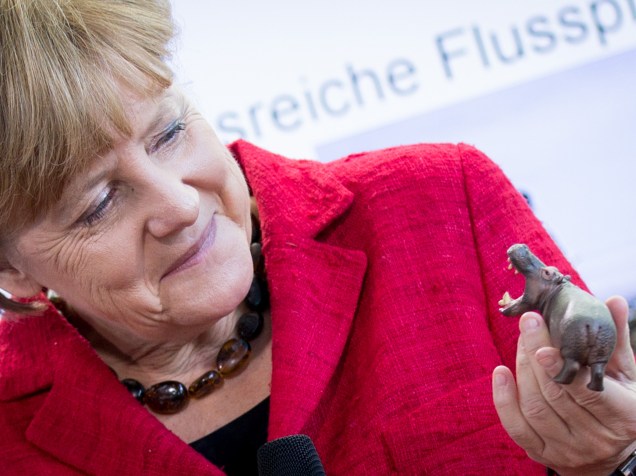 A chanceler alemã Angela Merkel segura um hipopótamo de brinquedo na chancelaria em Berlim, onde recebeu vencedores de uma competição de ciência para jovens