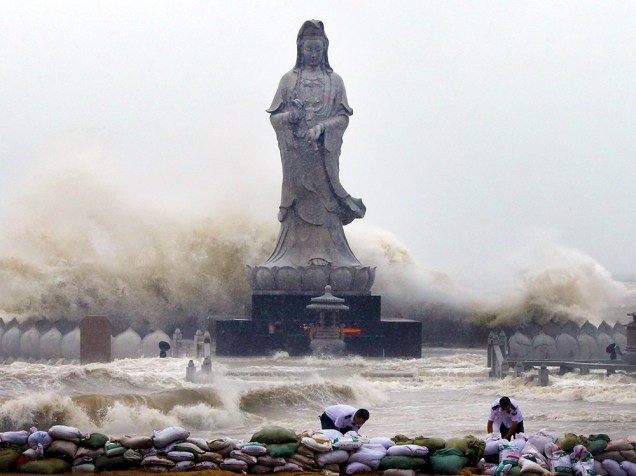 Chineses colocam sacos de areia para reforçar um dique, o mar esta agitado pelo tufão Dujuan