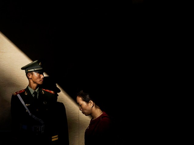 Agente da polícia paramilitar chinesa guarda um túnel durante a cerimônia oficial de hasteamento da bandeira na Praça da Paz Celestial  para marcar o 66º Dia Nacional em Pequim - 01/10/2015