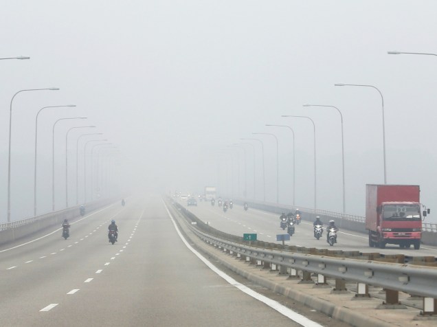 Motoristas passam por estrada coberta de neblina no sul da Malásia - 06/10/2015