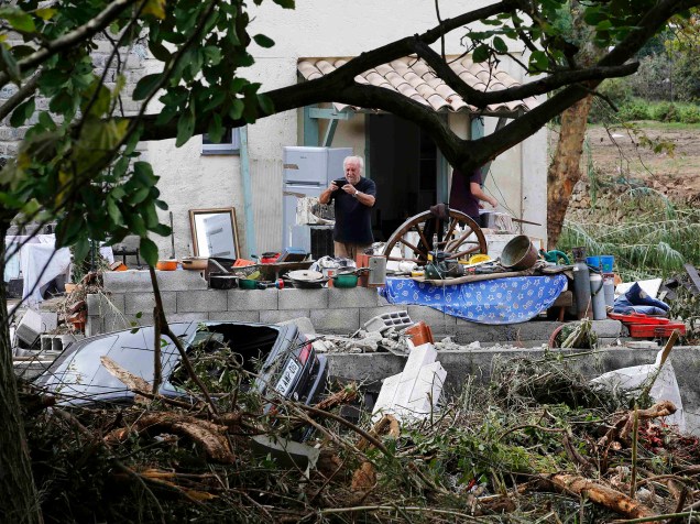 Homem fotografa a casa devastada por inundações em Biot, sudeste da França, nesta terça-feira (06)
