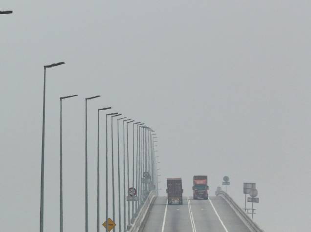 Caminhões atravessam ponte envolta por neblina causada por poluição em Klang, na Malásia. A qualidade do ar piorou na região desde que resquícios de queimadas nas ilhas de Sumatra e de Bórneu chegaram ao país - 07/10/2015