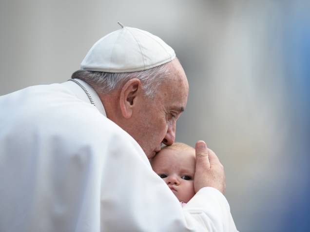 Papa Francisco beija bebê durante sua chegada à Praça de São Pedro, no Vaticano, para celebrar sua audiência semanal - 07/10/2015