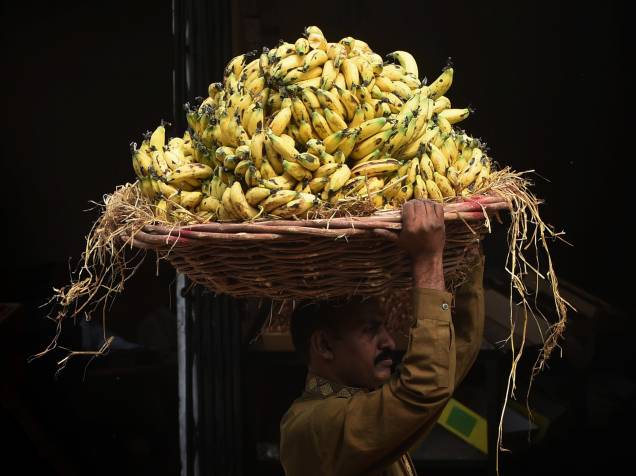 Trabalhador carrega uma cesta de bananas em um mercado de frutas em Lahore, no Paquistão - 19/10/2015