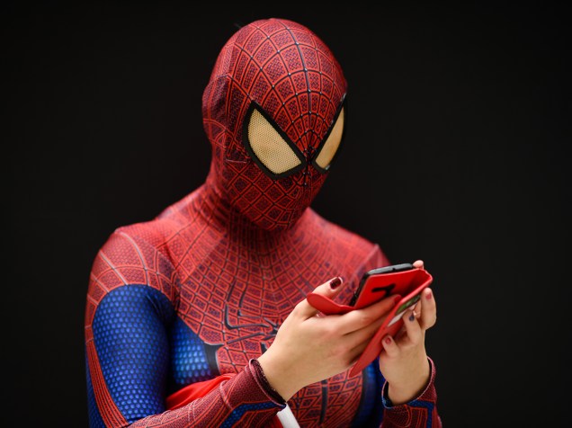 Mulher vestida de Homem Aranha usa seu celular na Comic Con de Londres, na Inglaterra - 23/10/2015